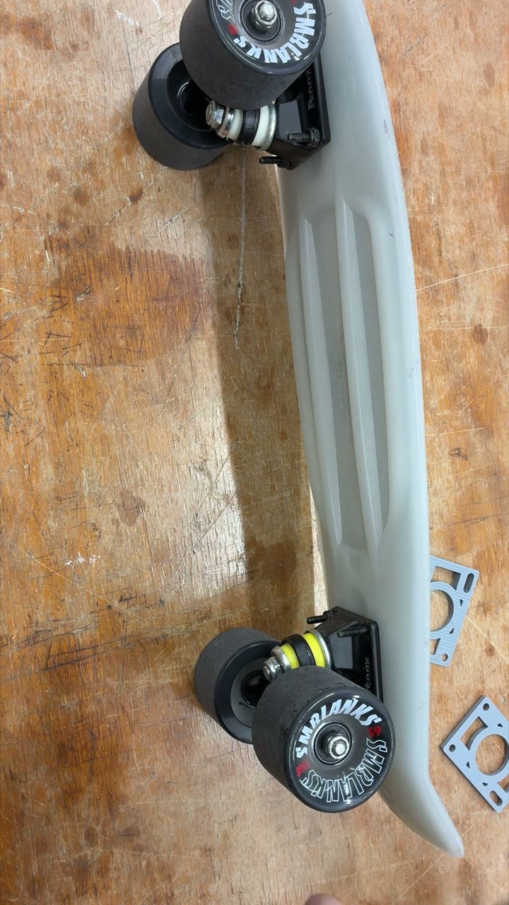 Installing skateboard hardware bolts through a deck and riser pad with a skate tool